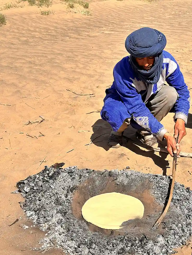 Traditional nomad sandbread being baked in the desert near Erg Chigaga